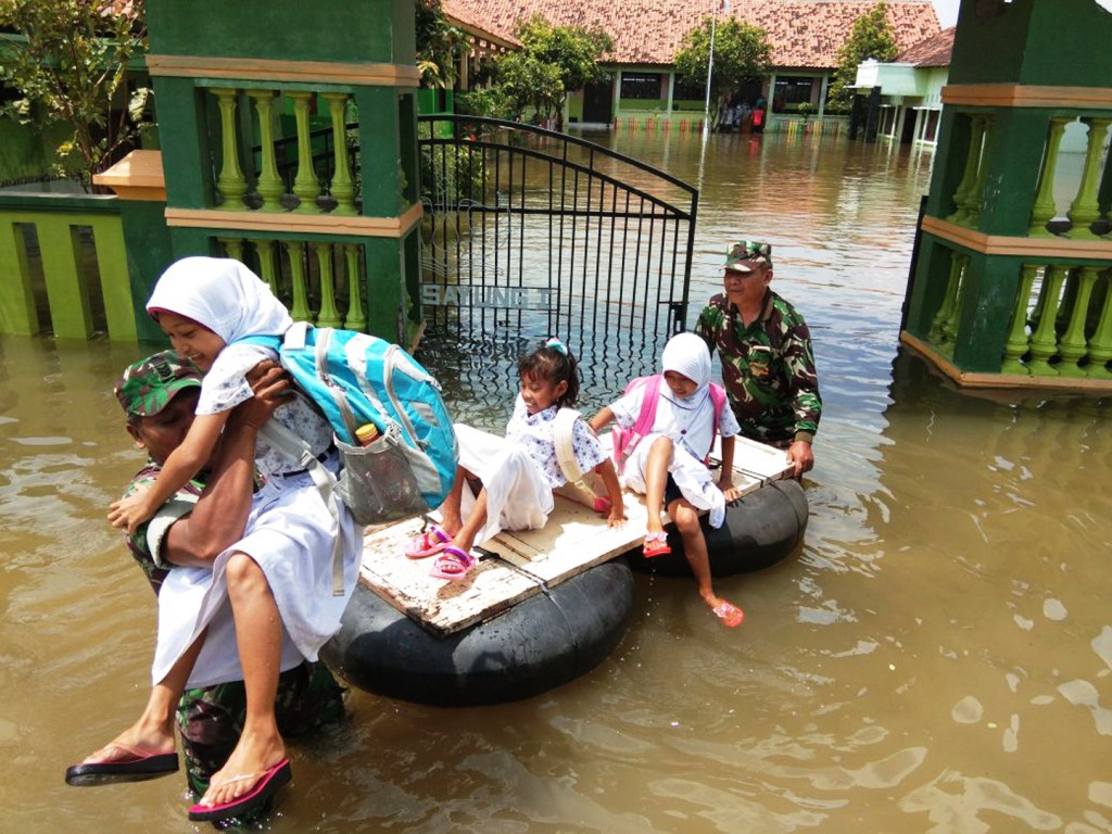 Tanpa Ada Keraguan Babinsa Melintasi Banjir Untuk Membantu Anak Bersekolah